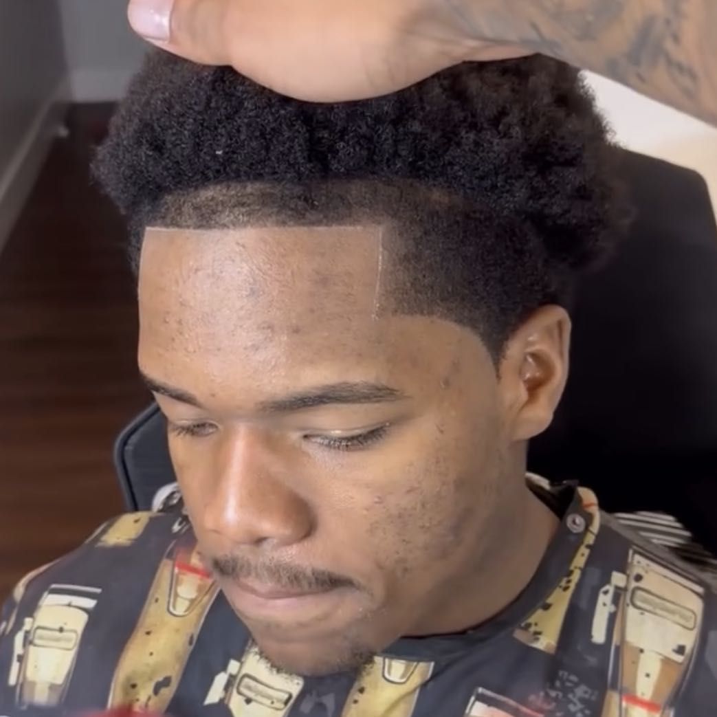 Barber at work inside AxellCuts, Harlem NYC